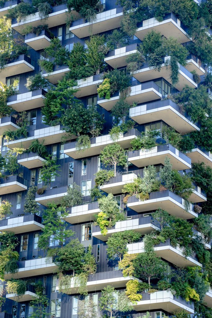 Modern eco-friendly building with lush greenery on balconies in Milan, Italy.